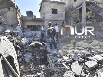 Civilians, paramedics, and Civil Defense Search and Rescue teams conduct search and rescue operations among the rubble of collapsed building...