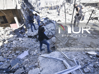 Civilians, paramedics, and Civil Defense Search and Rescue teams conduct search and rescue operations among the rubble of collapsed building...