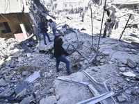 Civilians, paramedics, and Civil Defense Search and Rescue teams conduct search and rescue operations among the rubble of collapsed building...