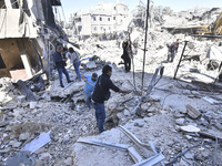 Civilians, paramedics, and Civil Defense Search and Rescue teams conduct search and rescue operations among the rubble of collapsed building...