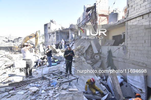 Civilians, paramedics, and Civil Defense Search and Rescue teams conduct search and rescue operations among the rubble of collapsed building...