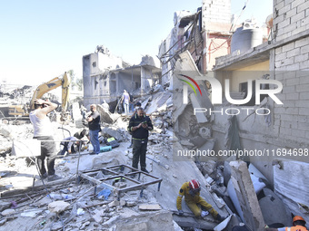 Civilians, paramedics, and Civil Defense Search and Rescue teams conduct search and rescue operations among the rubble of collapsed building...