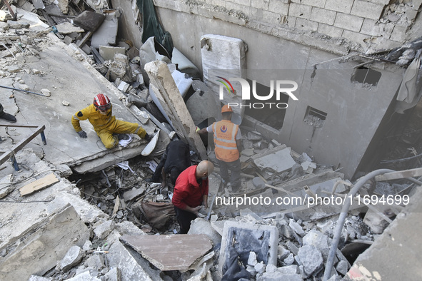 Civilians, paramedics, and Civil Defense Search and Rescue teams conduct search and rescue operations among the rubble of collapsed building...