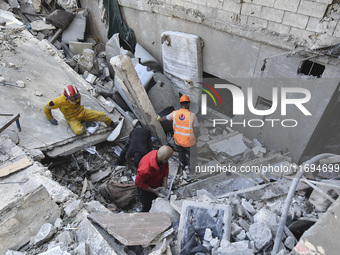 Civilians, paramedics, and Civil Defense Search and Rescue teams conduct search and rescue operations among the rubble of collapsed building...