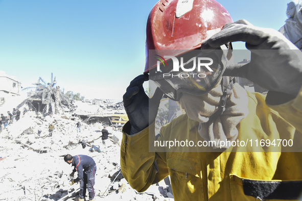 Civilians, paramedics, and Civil Defense Search and Rescue teams conduct search and rescue operations among the rubble of collapsed building...