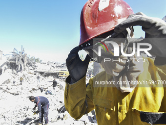 Civilians, paramedics, and Civil Defense Search and Rescue teams conduct search and rescue operations among the rubble of collapsed building...