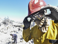 Civilians, paramedics, and Civil Defense Search and Rescue teams conduct search and rescue operations among the rubble of collapsed building...