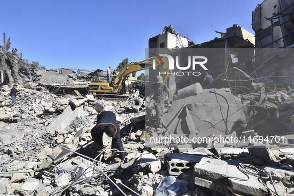 Civilians, paramedics, and Civil Defense Search and Rescue teams conduct search and rescue operations among the rubble of collapsed building...