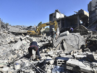 Civilians, paramedics, and Civil Defense Search and Rescue teams conduct search and rescue operations among the rubble of collapsed building...