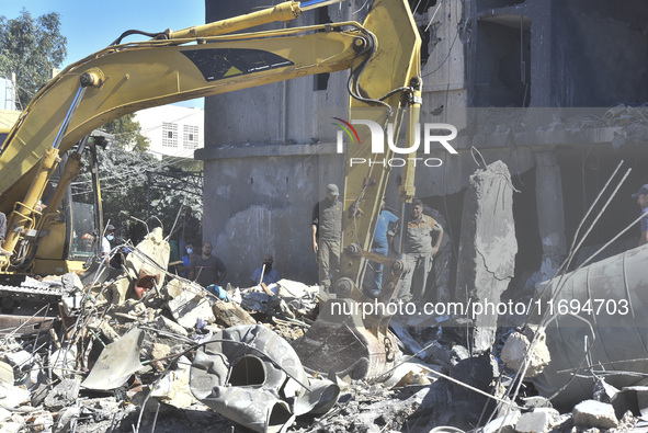 Civilians, paramedics, and Civil Defense Search and Rescue teams conduct search and rescue operations among the rubble of collapsed building...