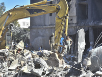 Civilians, paramedics, and Civil Defense Search and Rescue teams conduct search and rescue operations among the rubble of collapsed building...