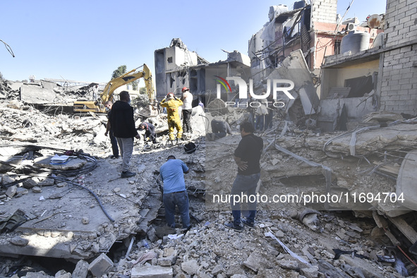 Civilians, paramedics, and Civil Defense Search and Rescue teams conduct search and rescue operations among the rubble of collapsed building...