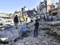 Civilians, paramedics, and Civil Defense Search and Rescue teams conduct search and rescue operations among the rubble of collapsed building...