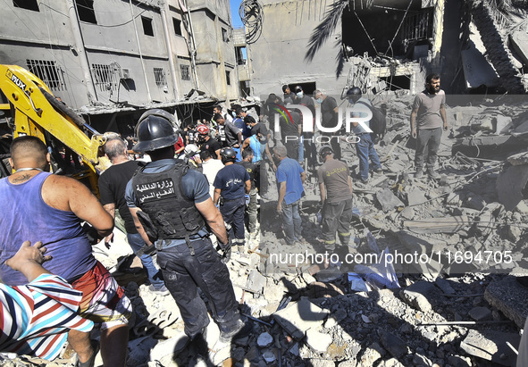 Civilians, paramedics, and Civil Defense Search and Rescue teams conduct search and rescue operations among the rubble of collapsed building...