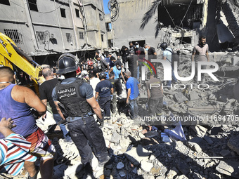 Civilians, paramedics, and Civil Defense Search and Rescue teams conduct search and rescue operations among the rubble of collapsed building...