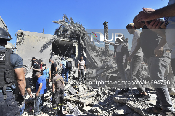 Civilians, paramedics, and Civil Defense Search and Rescue teams conduct search and rescue operations among the rubble of collapsed building...