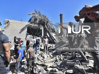 Civilians, paramedics, and Civil Defense Search and Rescue teams conduct search and rescue operations among the rubble of collapsed building...