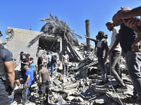 Civilians, paramedics, and Civil Defense Search and Rescue teams conduct search and rescue operations among the rubble of collapsed building...