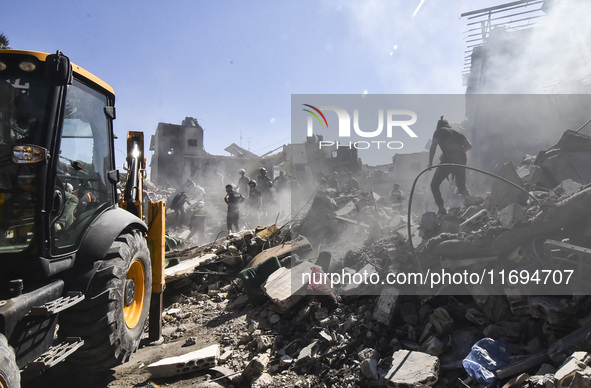 Civilians, paramedics, and Civil Defense Search and Rescue teams conduct search and rescue operations among the rubble of collapsed building...