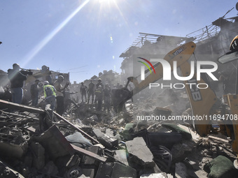 Civilians, paramedics, and Civil Defense Search and Rescue teams conduct search and rescue operations among the rubble of collapsed building...