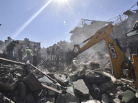 Civilians, paramedics, and Civil Defense Search and Rescue teams conduct search and rescue operations among the rubble of collapsed building...