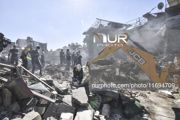 Civilians, paramedics, and Civil Defense Search and Rescue teams conduct search and rescue operations among the rubble of collapsed building...