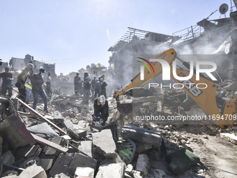 Civilians, paramedics, and Civil Defense Search and Rescue teams conduct search and rescue operations among the rubble of collapsed building...