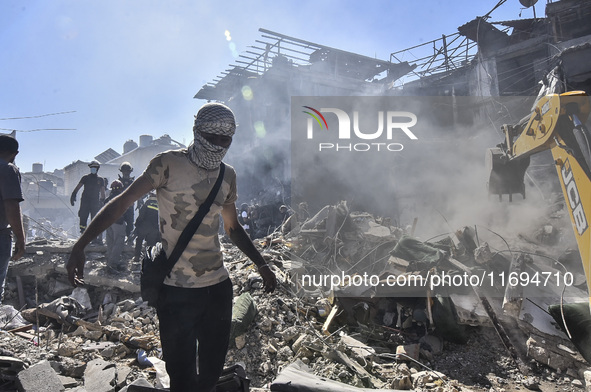 Civilians, paramedics, and Civil Defense Search and Rescue teams conduct search and rescue operations among the rubble of collapsed building...