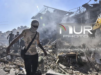 Civilians, paramedics, and Civil Defense Search and Rescue teams conduct search and rescue operations among the rubble of collapsed building...