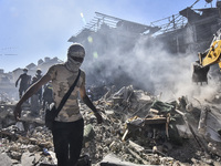 Civilians, paramedics, and Civil Defense Search and Rescue teams conduct search and rescue operations among the rubble of collapsed building...