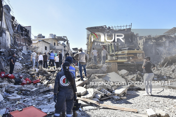 Civilians, paramedics, and Civil Defense Search and Rescue teams conduct search and rescue operations among the rubble of collapsed building...