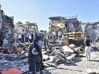 Civilians, paramedics, and Civil Defense Search and Rescue teams conduct search and rescue operations among the rubble of collapsed building...