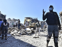 Civilians, paramedics, and Civil Defense Search and Rescue teams conduct search and rescue operations among the rubble of collapsed building...