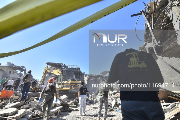 Civilians, paramedics, and Civil Defense Search and Rescue teams conduct search and rescue operations among the rubble of collapsed building...