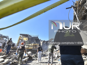 Civilians, paramedics, and Civil Defense Search and Rescue teams conduct search and rescue operations among the rubble of collapsed building...