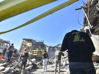 Civilians, paramedics, and Civil Defense Search and Rescue teams conduct search and rescue operations among the rubble of collapsed building...