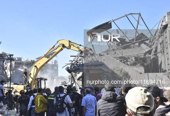 Civilians, paramedics, and Civil Defense Search and Rescue teams conduct search and rescue operations among the rubble of collapsed building...