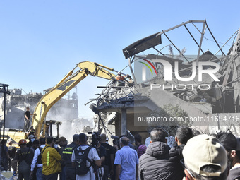 Civilians, paramedics, and Civil Defense Search and Rescue teams conduct search and rescue operations among the rubble of collapsed building...