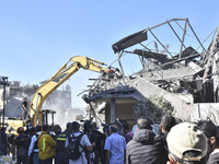 Civilians, paramedics, and Civil Defense Search and Rescue teams conduct search and rescue operations among the rubble of collapsed building...