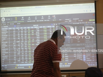 A trader stands in front of a screen during the Dhaka Stock Exchange trading session at a Brokerage House in Dhaka, Bangladesh, on October 2...