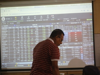 A trader stands in front of a screen during the Dhaka Stock Exchange trading session at a Brokerage House in Dhaka, Bangladesh, on October 2...