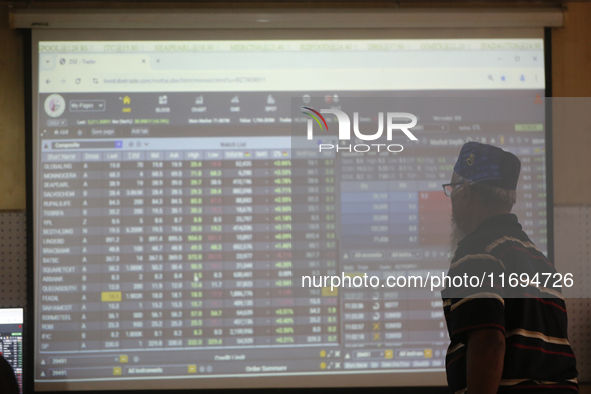 A trader looks up at a screen during the Dhaka Stock Exchange trading session at a Brokerage House in Dhaka, Bangladesh, on October 22, 2024...