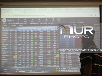 A trader looks up at a screen during the Dhaka Stock Exchange trading session at a Brokerage House in Dhaka, Bangladesh, on October 22, 2024...