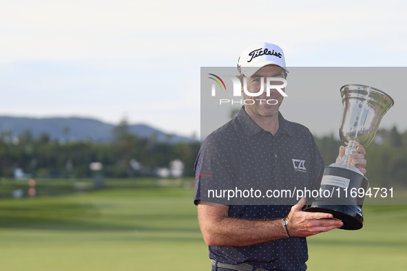 Julien Guerrier of France poses with the trophy on the 18th green after winning a nine-hole play-off during day four of the Estrella Damm N....