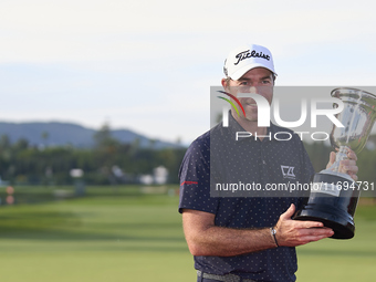 Julien Guerrier of France poses with the trophy on the 18th green after winning a nine-hole play-off during day four of the Estrella Damm N....