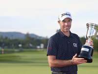 Julien Guerrier of France poses with the trophy on the 18th green after winning a nine-hole play-off during day four of the Estrella Damm N....