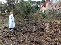 A woman stands at a crater in the ground after the October 18 Russian missile strike in Odesa, Ukraine, on October 19, 2024. (