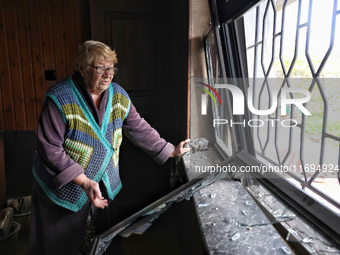 A woman stands by a smashed window after the October 18 Russian missile strike in Odesa, Ukraine, on October 19, 2024. NO USE RUSSIA. NO USE...