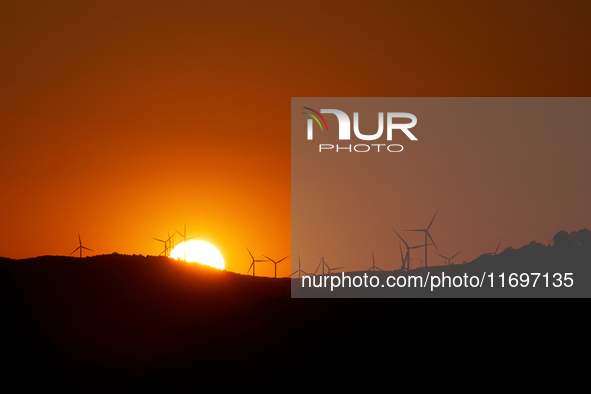 Wind energy is produced at sunset by the wind farm near Pietrapertosa in Basilicata on June 16, 2020. 