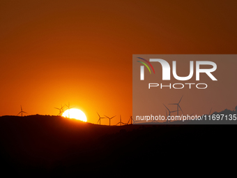 Wind energy is produced at sunset by the wind farm near Pietrapertosa in Basilicata on June 16, 2020. (